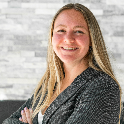 Retrato de Cassidy Cabanzo, REALTOR en Utah, sonriendo con los brazos cruzados